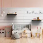 A pastel-themed nursery with a crib, plush animal toys, a stuffed animal chair, and a small table with bunny-shaped chairs. Shelves hold more toys and decorations, and a sign on the wall reads "Sweet Dreams Charlotte." This once ordinary garage has been transformed into a cozy, modern haven.